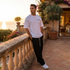 Homme portant le t-shirt blanc Tourismo Club Ferrari F40 sur une terrasse méditerranéenne en fin de journée
