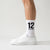 Chaussettes Ayrton Senna 12, saison 1988 blanc, portées de profil avec des sneakers blanches